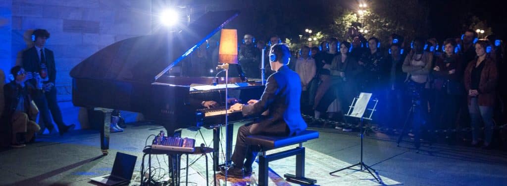 Pianist in concert with the audience on headphones