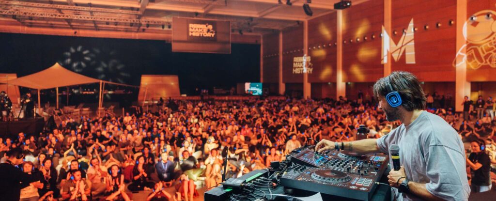 Large event with lights and audience on headphones